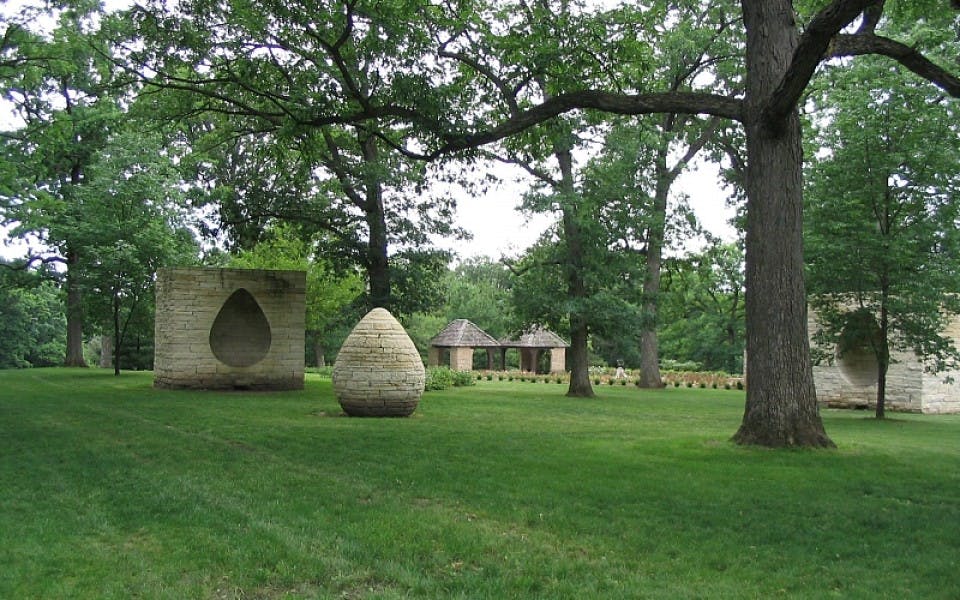 Three Cairns by Andy Goldworthy, 2002. [An egg-shaped stone sculpture stands before a block of stone with the shape of an egg cut out of it.]